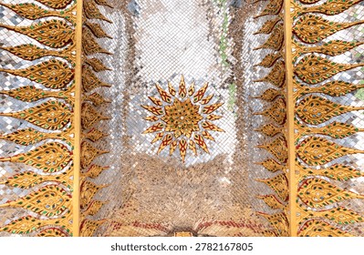 Sacred geometric ceiling pattern inside a Thai temple featuring symmetrical gold motifs, mirrored surfaces, and intricate Buddhist decorative artistry.