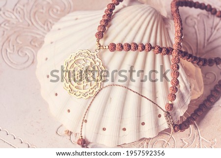 Sacred geometry spiritual brass pendant rudraksha seed necklace on white shell background