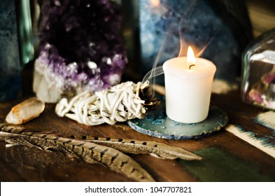 sacred space still life with amethyst candle feathers and sage