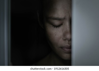 A Sad Afraid Woman Hiding In A Dark Closet Alone At Home.