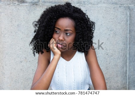 Sad african american  with curly black hair looking around