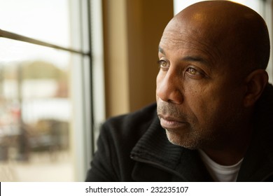 Sad African American man looking out the window. - Shutterstock ID 232235107