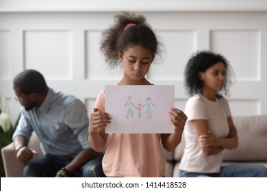 Sad African American School Child Girl Holding Family Picture Drawing Feeling Upset About Parents Divorce, Innocent Sensitive Little Kid Suffer From Trauma Offended By Fights Conflicts Shared Custody