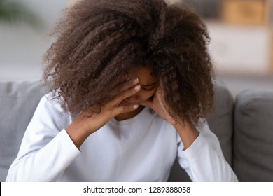 Sad African American Teen Girl Sit On Couch At Home Crying, Having Problems With Parents Or Friends, Disappointed Black Teenager Feel Lonely, Experience Troubles Being Loner Or Outcast At School