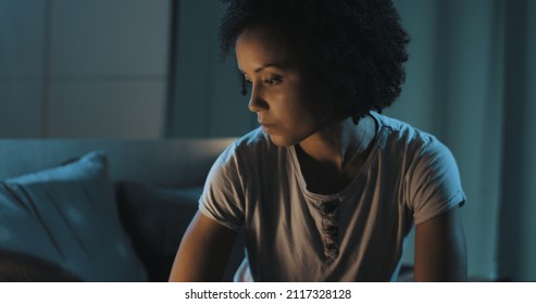 Sad African American Woman Sitting On Bed At Night, She Can't Sleep