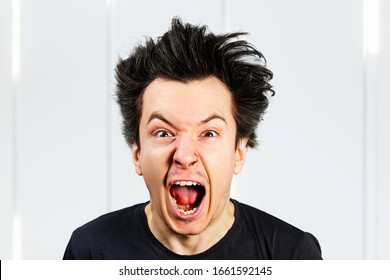 Sad anger young guy look in camera and cry with open mouth and scream, on white background