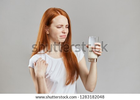 sad angry girl hate milk. dislike, frustration, disgusting drink . close up side view portrait. studio shot