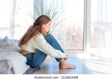 Sad And Angry Teenage Girl Sitting On The Floor In The Room. Teenager Problems Concept