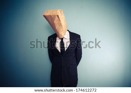 sad and ashamed businessman with bag over head