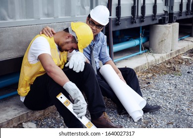 Sad Asian fired arab foreman cry while senior engineer manager cheer up at construction site. 2020 bad economy due to covid-19 or coronavirus pandemic positive. Layoff employees, Work from home.