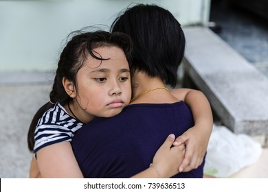 The Sad Asian Girl Child Hugs Her Mother