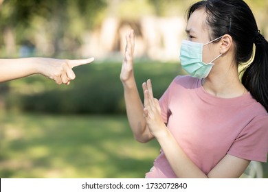 Sad Asian Girl Student In Hygienic Mask During The Pandemic Of Coronavirus Or Covid-19,hand Pointing Finger To Scared Child Girl,bullying Victim And Hate,anti Racism,stop Xenophobia,bullied By Society