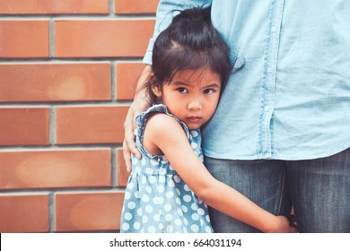 Sad Asian Kid Girl Hugging Her Mother Leg In Vintage Color Tone