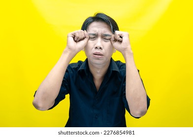 A sad asian man is crying and wiping away tears after having a problems. stressful man cries out loudly. a worker crying after losing his job. - Shutterstock ID 2276854981