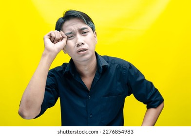 A sad asian man is crying and wiping away tears after having a problems. stressful man cries out loudly. a worker crying after losing his job. - Shutterstock ID 2276854983