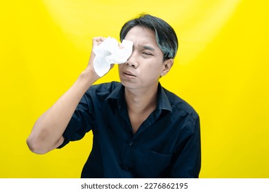 A sad Asian man is crying and wiping away tears after having problems using tissues. After losing his job, a man was seen crying deeply and wiping his tears with tissues.  - Shutterstock ID 2276862195