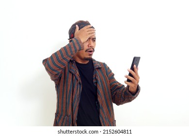 Sad Asian Man Standing While Reading A Bad News On His Cell Phone. Isolated On White Background