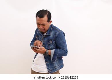 Sad Asian Man Standing While Holding A Cell Phone. Isolated On White Background