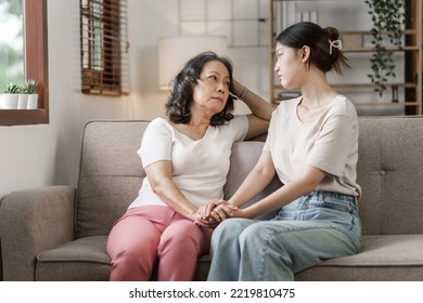 Sad asian mature woman grown up daughter or grandkid sitting on sofa hugging desperate, My heart warms to you, dear mommy. - Shutterstock ID 2219810475