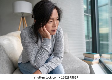 Sad Asian Mature Woman Lonely At Home Self Isolation Quarantine For COVID-19 Coronavirus Social Distancing Prevention. Mental Health, Anxiety Depressed Thinking Senior Chinese Lady.