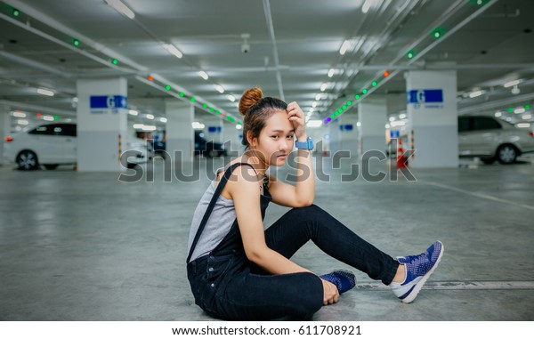 sad Asian
woman hug her knee and cry in car
park