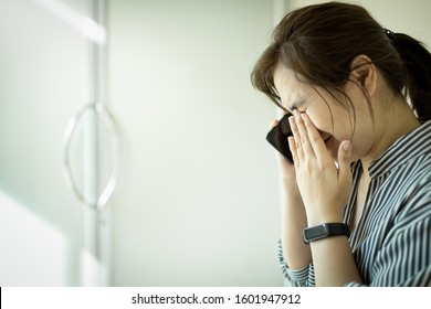 Sad Asian Woman Using Phone And Grieving,crying Alone In Hospital,female People Waiting For The Doctor In Front Of The ICU Room,feel Stressed And Worried About Her Husband About Emergency Accident