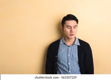 Sad Asian Young Man In The Studio Yellow Background