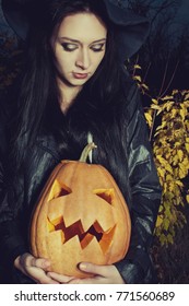 Sad beautiful witch with pumpkin. Outdoors shooting. - Shutterstock ID 771560689