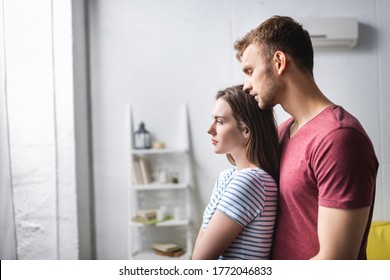 Sad Beautiful Young Couple Hugging At Home