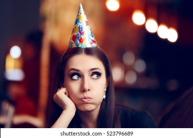 Sad Bored Woman At A Party Having No Fun - Portrait Of A Funny Girl With Party Hat Making Faces 
