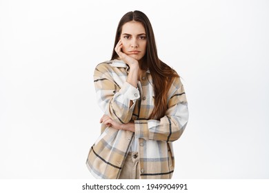 Sad Or Bored Woman Stare Indifferent At Camera, No Emotions Poker Face, Lean Head On Palm And Looking At Something Boring, Standing Against White Background