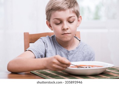 Sad Boy Eating Tomato Soup For Dinner