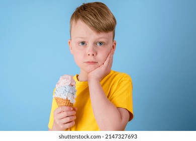 Sad Boy Grabbed His Cheek Felt A Sharp Toothache. The Child Holding Ice Cream In His Hand. Dental Care, Health Care Concept. High Quality Photo