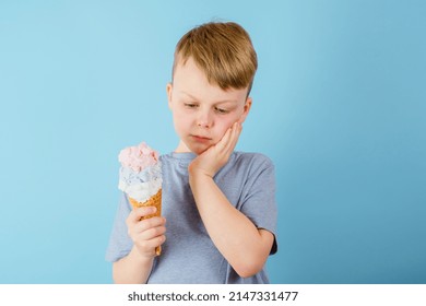 Sad Boy Grabbed His Cheek Felt A Sharp Toothache. The Child Holding Ice Cream In His Hand. Dental Care, Health Care Concept. High Quality Photo