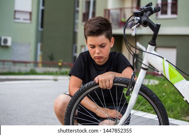 Sad Boy Looking At His Flat Bike Tire, Kid Staring At The Bicycle With The Broken Wheel