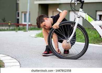 Sad Boy Looking At His Flat Bike Tire, Kid Staring At The Bicycle With The Broken Wheel