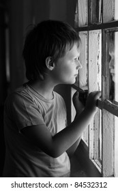 Sad Boy Looking In Window. Black And White.