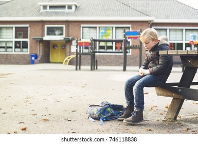 sad boy outside at schoolyard