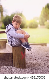 Sad Boy Sitting Alone On Playground