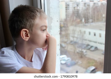 The sad boy sitting on the windowsill - Shutterstock ID 1790810978