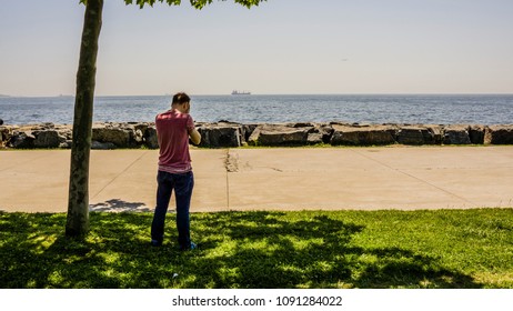 Sad Boy Standing Alone And Closing Or Hiding His Face With His Hands And Feeling Upset. Unhappy Man Crying And Feeling Lonely At Seaside. Time To Say Goodbye. Time To Go. Missing Someone Concept.