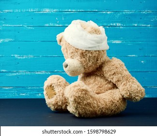 Sad Brown Bear Sits With Bandaged White Medical Bandage Head,injury And Headache Concept