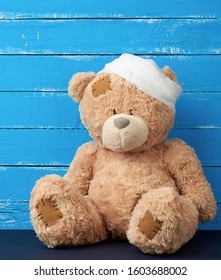 Sad Brown Bear Sits With Bandaged White Medical Bandage Head, Injury And Headache Concept