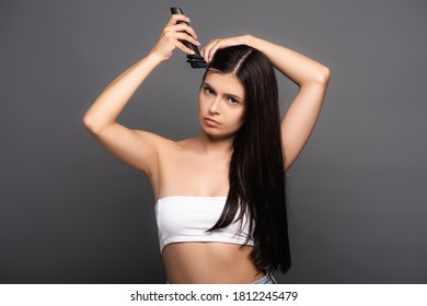 Sad Brunette Long Haired Woman Shaving Head With Electric Razor Isolated On Black