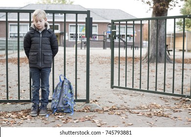 Sad Bullied Kid. No Friends, Standing Alone At The School Gate.