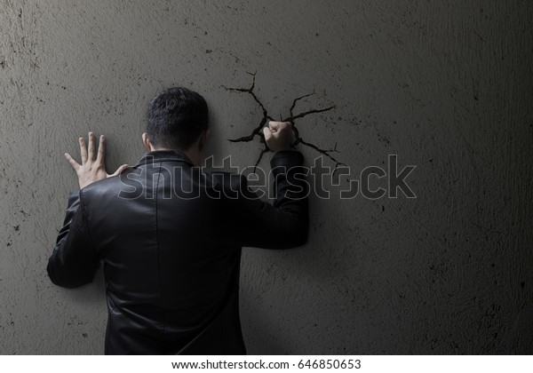 Sad business man
feeling bad, hopeless, depressed, frustrated and repressed, Man hit
the wall. Wall crack.