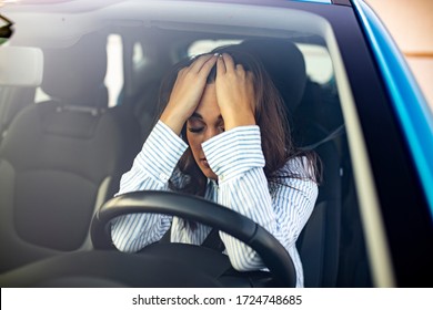 Sad businesswoman having problems while driving a car at sunset. In troubles - unhappy woman in car. Young woman with hands on eyes sitting depressed in car - Powered by Shutterstock