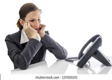 Sad Businesswoman Sitting At White Office Desk Waiting For A Phone Call.