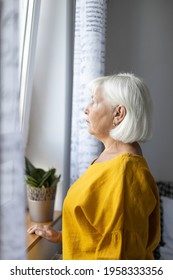 Sad Caucasian Woman 50 Years Old Looks Out The Window. Hope Concept. Concept Home Quarantine, Prevention COVID-19, Coronavirus