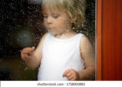 Sad Child Behind The Window On A Rainy Day